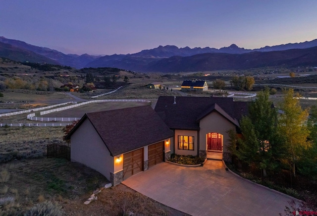 ranch-style home featuring stucco siding, an attached garage, and a mountain view