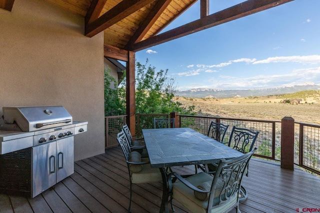 deck featuring grilling area, outdoor dining space, and a mountain view