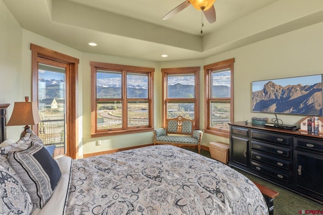 bedroom with baseboards, recessed lighting, multiple windows, and a raised ceiling