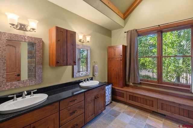 bathroom with double vanity, visible vents, a sink, and a chandelier
