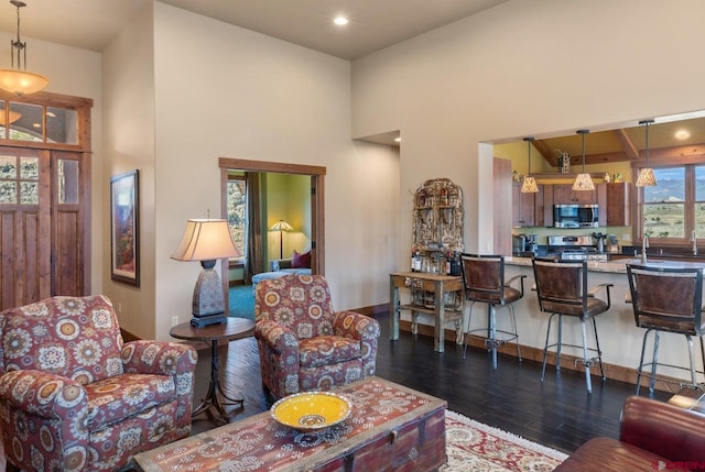 living room featuring a high ceiling, recessed lighting, and dark wood finished floors