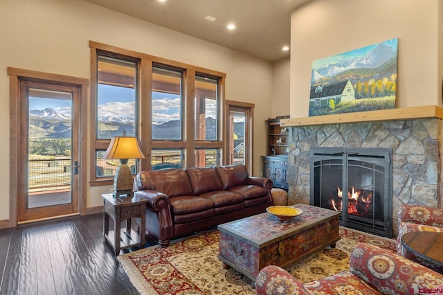 living area featuring recessed lighting, hardwood / wood-style floors, baseboards, a mountain view, and a fireplace