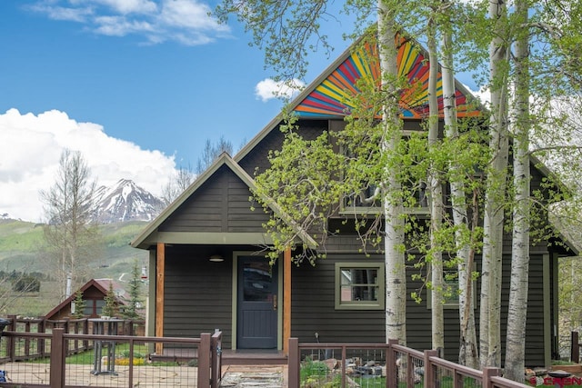 view of front of house featuring a porch, a fenced front yard, and a mountain view