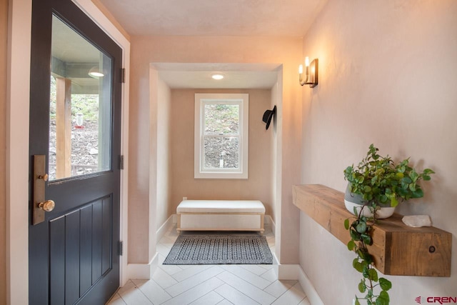 doorway to outside with light tile patterned floors and baseboards