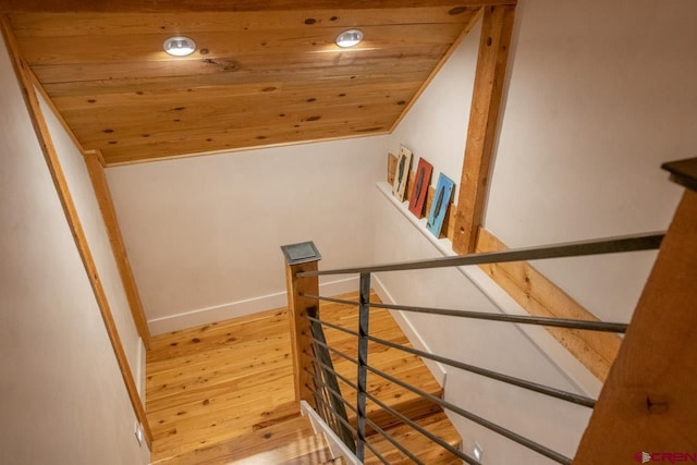 stairs with lofted ceiling, wooden ceiling, baseboards, and hardwood / wood-style flooring