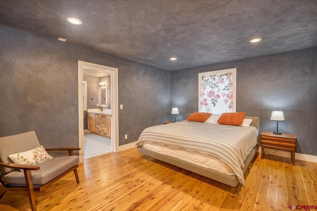 bedroom with light wood finished floors, recessed lighting, connected bathroom, and baseboards