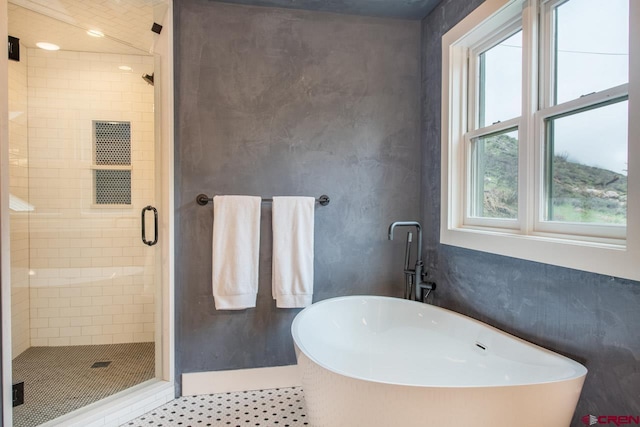 full bathroom featuring a stall shower and a freestanding tub