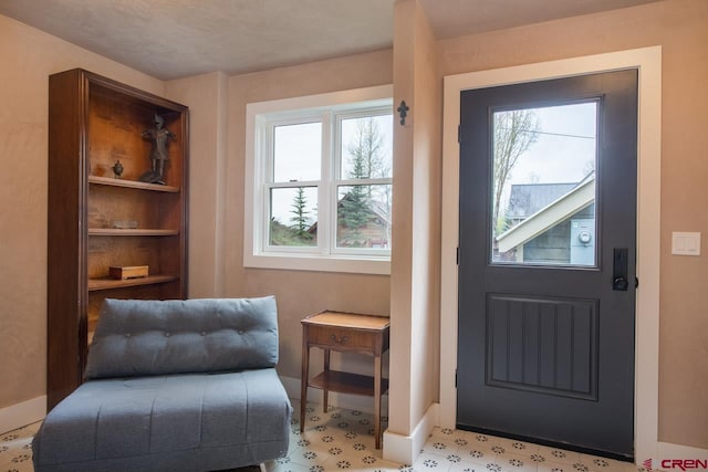 doorway to outside with baseboards