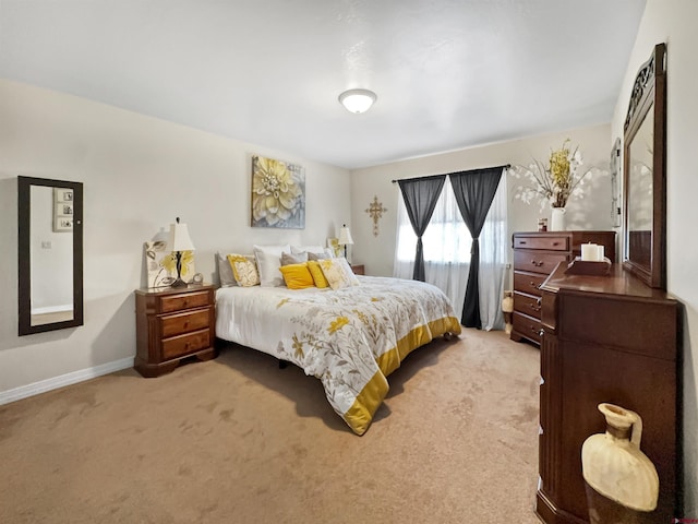 bedroom featuring light carpet and baseboards