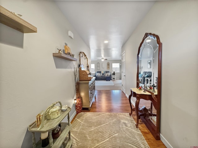 hallway featuring baseboards and wood finished floors