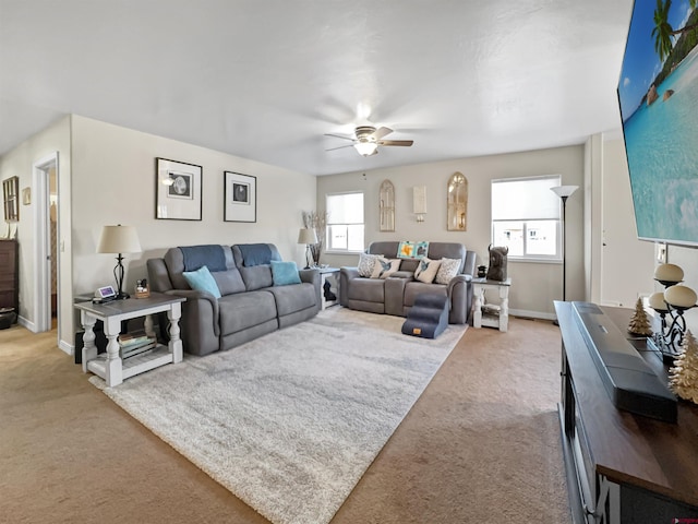 living area featuring carpet floors, a ceiling fan, and baseboards