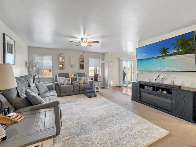 carpeted living room with a ceiling fan and baseboards