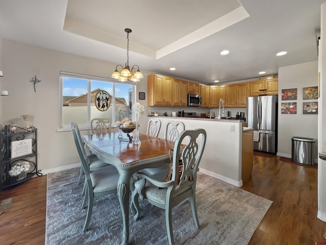 dining room featuring dark wood-style floors, a tray ceiling, a notable chandelier, recessed lighting, and baseboards