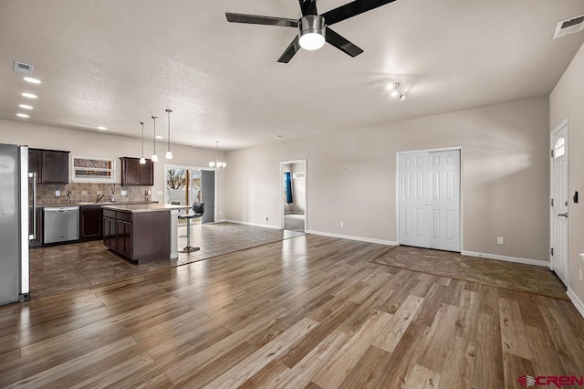 kitchen with visible vents, appliances with stainless steel finishes, a kitchen breakfast bar, and open floor plan