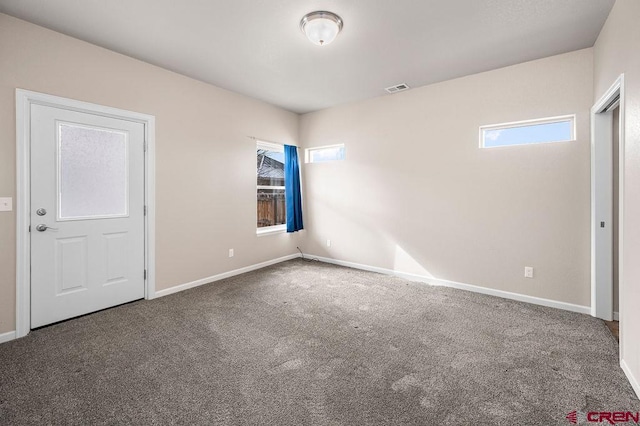 carpeted spare room with visible vents and baseboards