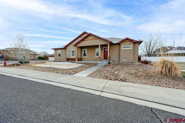 view of front facade with fence and stucco siding