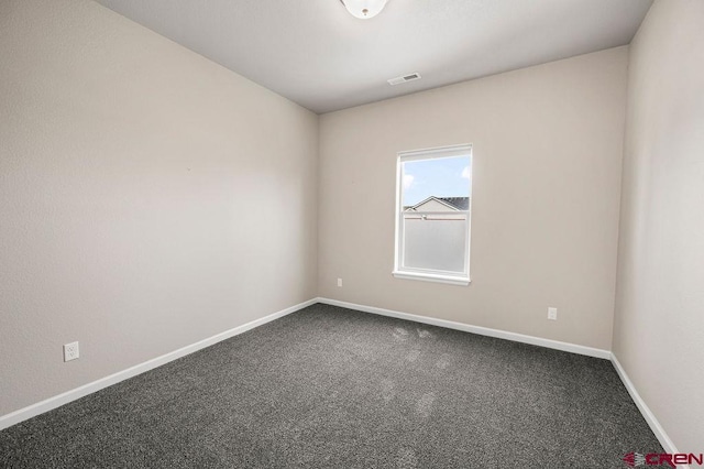 spare room featuring carpet, visible vents, and baseboards