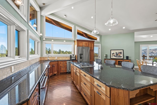 kitchen with brown cabinetry, a spacious island, dark wood-type flooring, stainless steel appliances, and open shelves