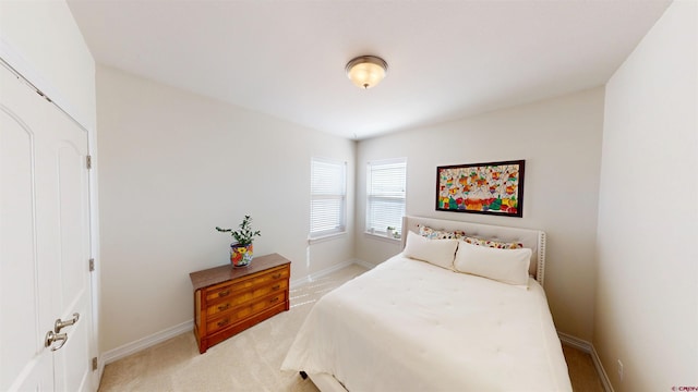 bedroom with light carpet and baseboards