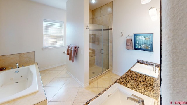 bathroom with a stall shower, tile patterned flooring, baseboards, and a sink