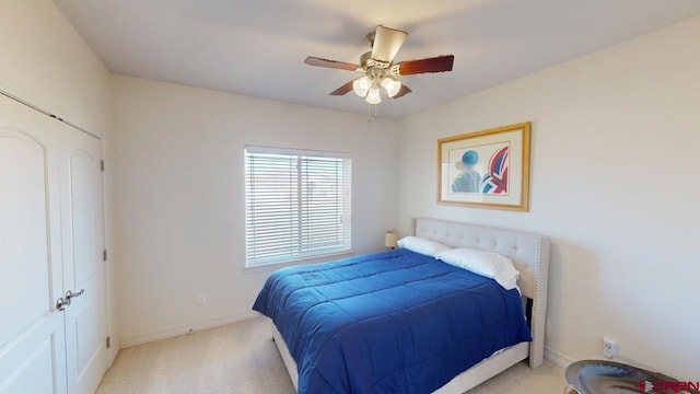 bedroom with light carpet, baseboards, and a ceiling fan