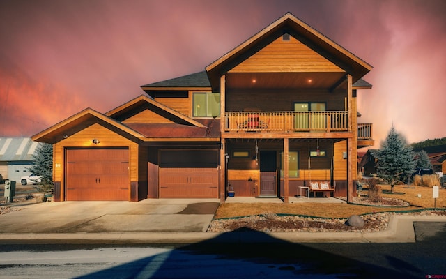 view of front of property with driveway, a balcony, and an attached garage