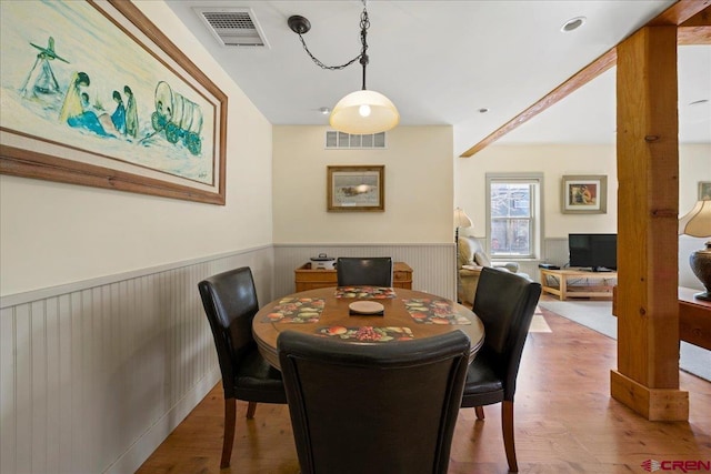 dining space featuring wainscoting, wood finished floors, and visible vents