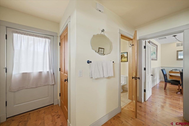 corridor with visible vents and light wood-style flooring