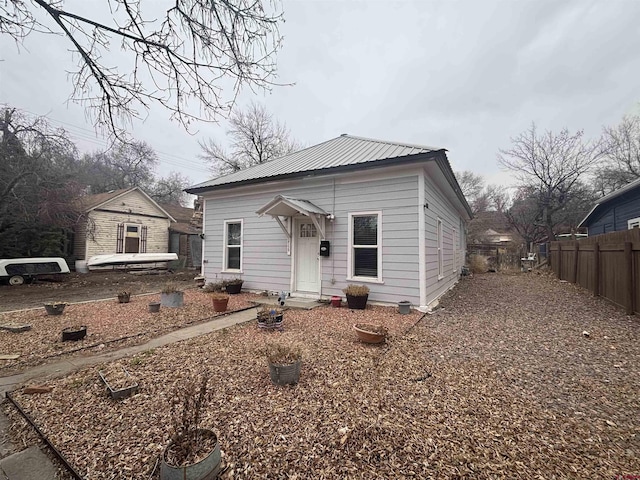 view of front of property with fence and metal roof