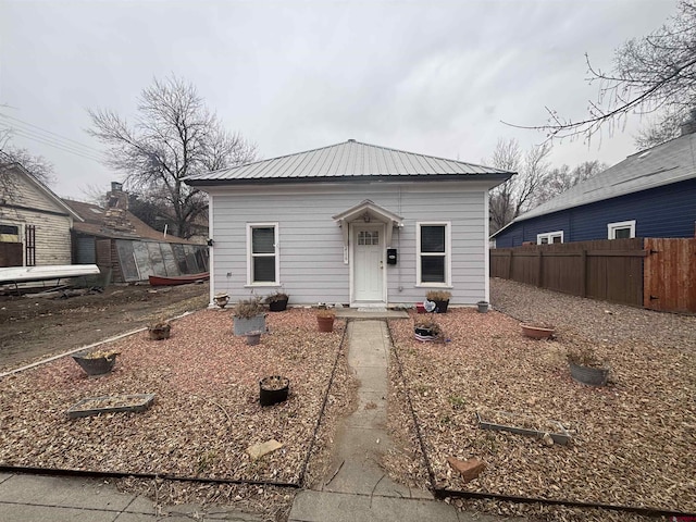 view of front of property with metal roof and fence