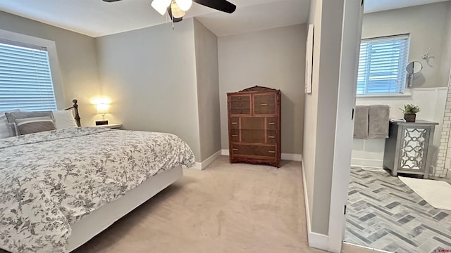 bedroom with light carpet, baseboards, and a ceiling fan