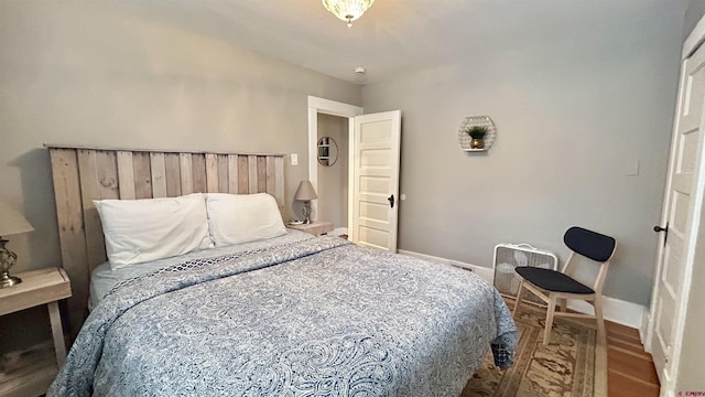 bedroom with baseboards and wood finished floors