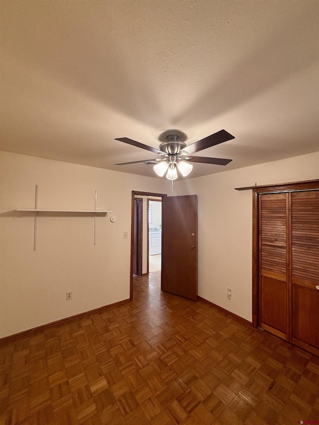 unfurnished bedroom with a closet, ceiling fan, a textured ceiling, and baseboards