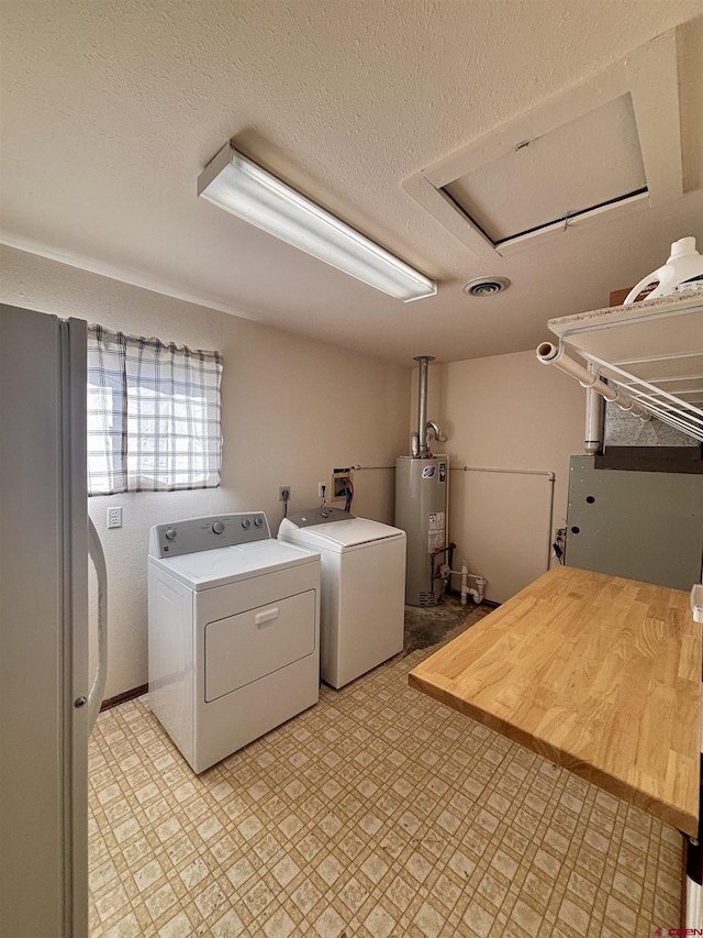 laundry room featuring laundry area, washer and clothes dryer, a textured ceiling, light floors, and gas water heater