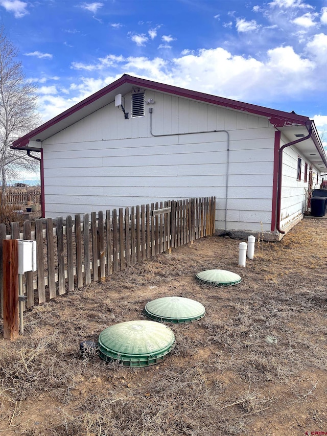 view of side of home featuring fence