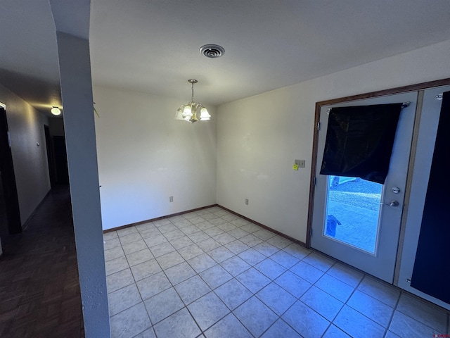 tiled spare room featuring an inviting chandelier, baseboards, and visible vents