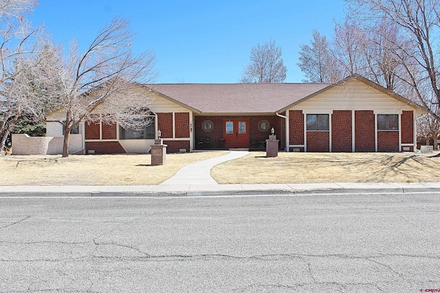 ranch-style home with a sunroom and brick siding