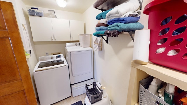 washroom featuring washing machine and dryer and cabinet space