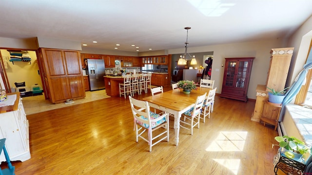 dining room featuring light wood-style floors, a notable chandelier, and recessed lighting