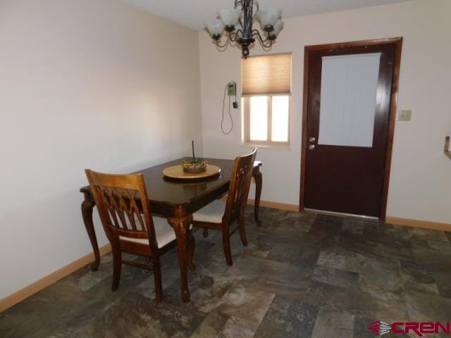 dining area with an inviting chandelier and baseboards