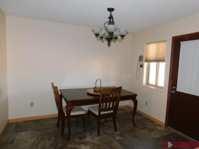 dining area with baseboards and a chandelier