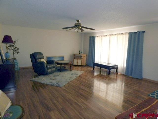 living room featuring a ceiling fan and wood finished floors