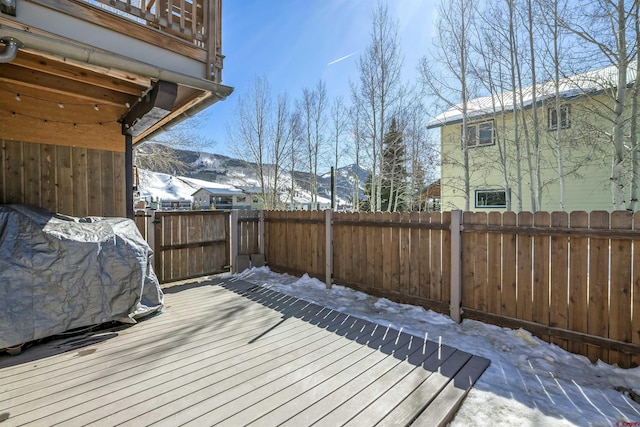 snow covered deck featuring a fenced backyard