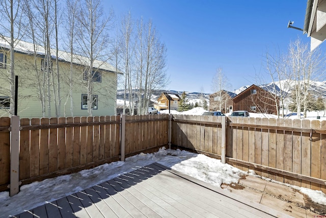 snow covered deck with a fenced backyard and a residential view