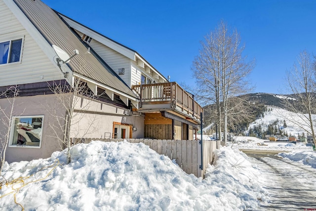 view of snowy exterior with a balcony