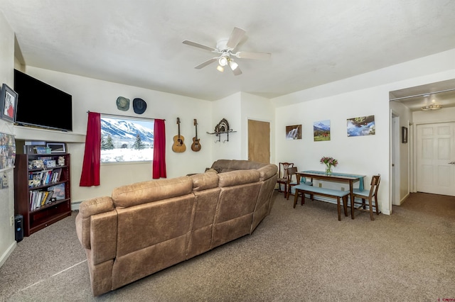 carpeted living area featuring a ceiling fan and a baseboard heating unit