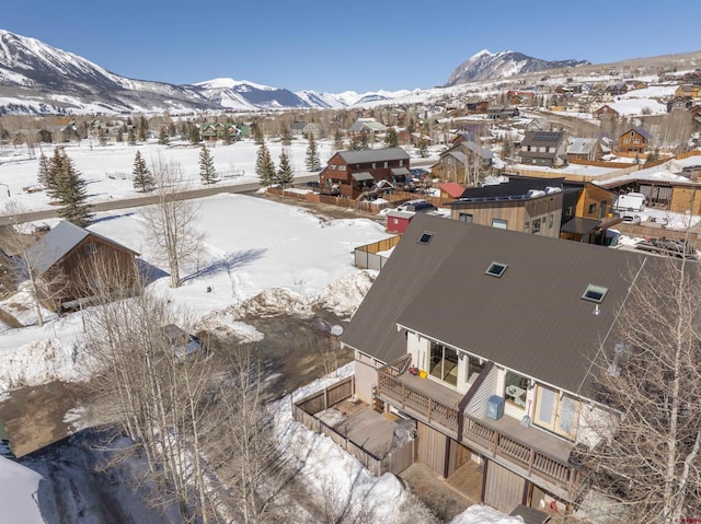 snowy aerial view with a residential view and a mountain view