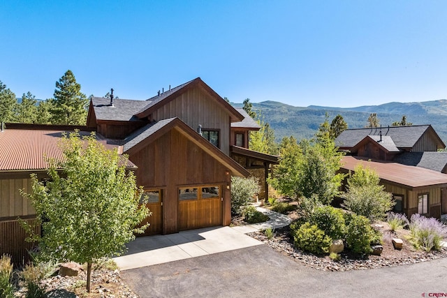 view of front of home with aphalt driveway, a mountain view, and a garage