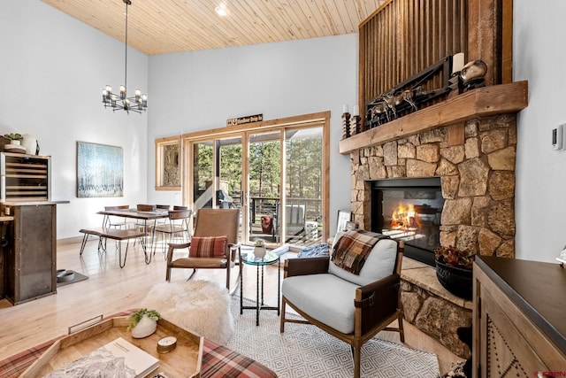 living area with wooden ceiling, wine cooler, wood finished floors, an inviting chandelier, and a fireplace