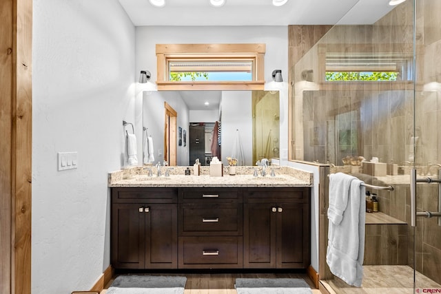 full bath with a stall shower, a sink, and double vanity